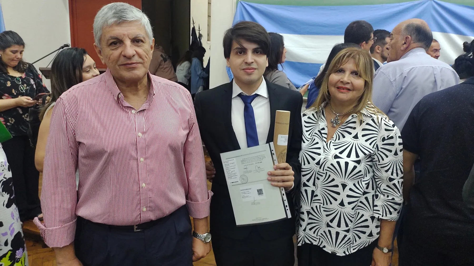 Luis Medina Raed con sus padres y su diploma en el aula magna de la FACET.