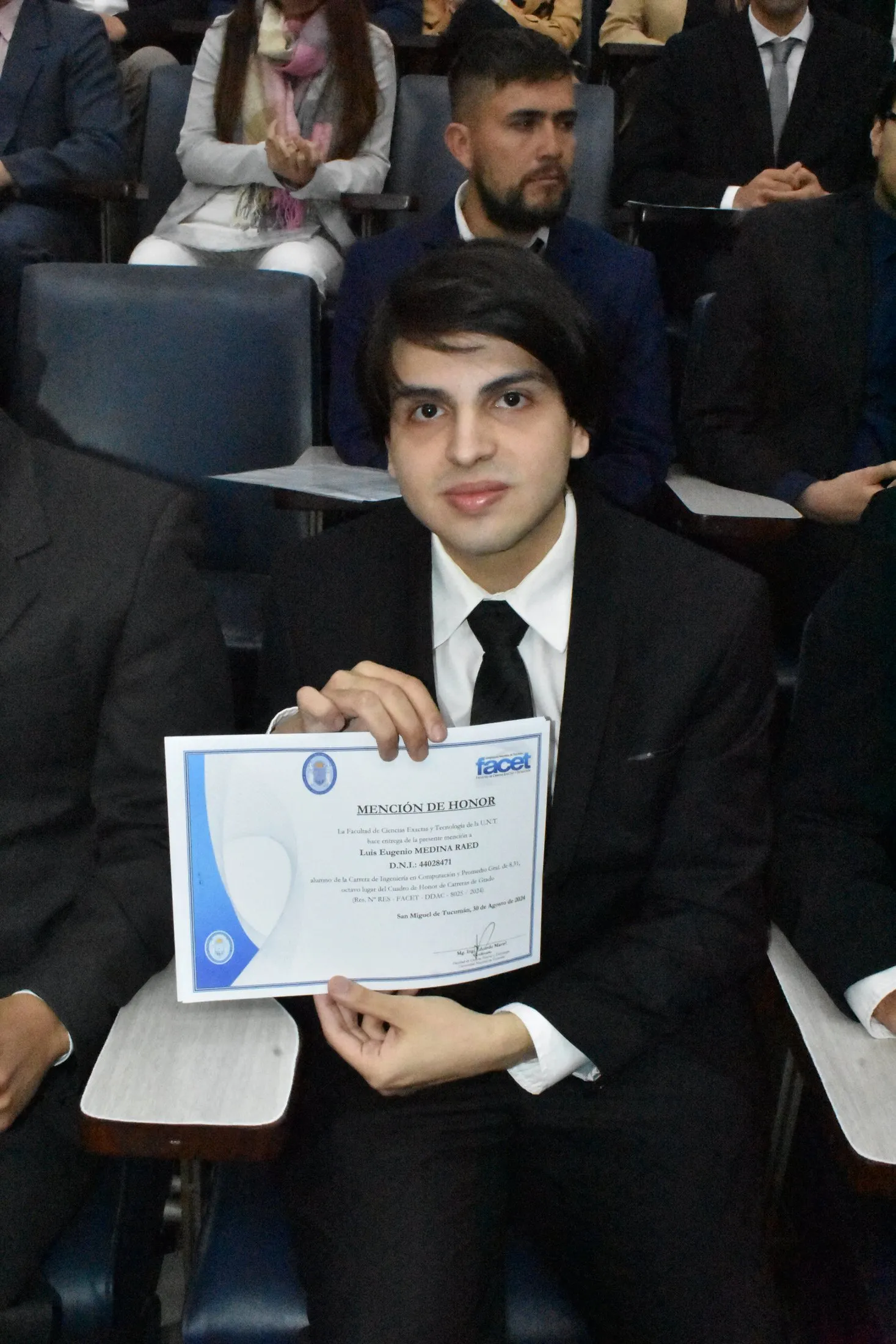 Luis Medina Raed montrant le diplôme de Mention d'honneur du Tableau d'honneur de la FACET.