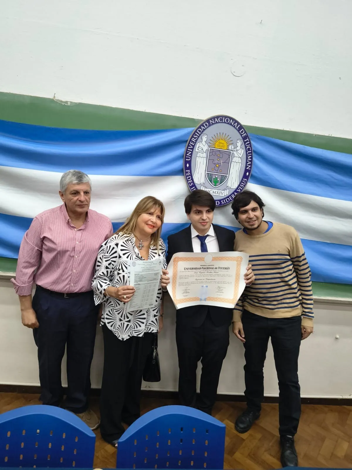 Luis Medina Raed con su familia y su diploma frente al escudo de la Universidad Nacional de Tucumán.